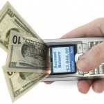 Money coming out of mobile phone as it is held in a female hand