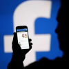 image of person viewing facebook on their mobile phone image of person viewing facebook on their mobile phone